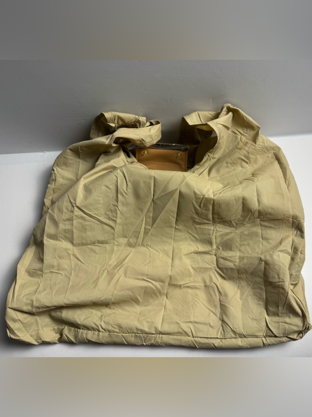 A foldable tote bag charm with carabiner clasp for easy use of reusable bag.